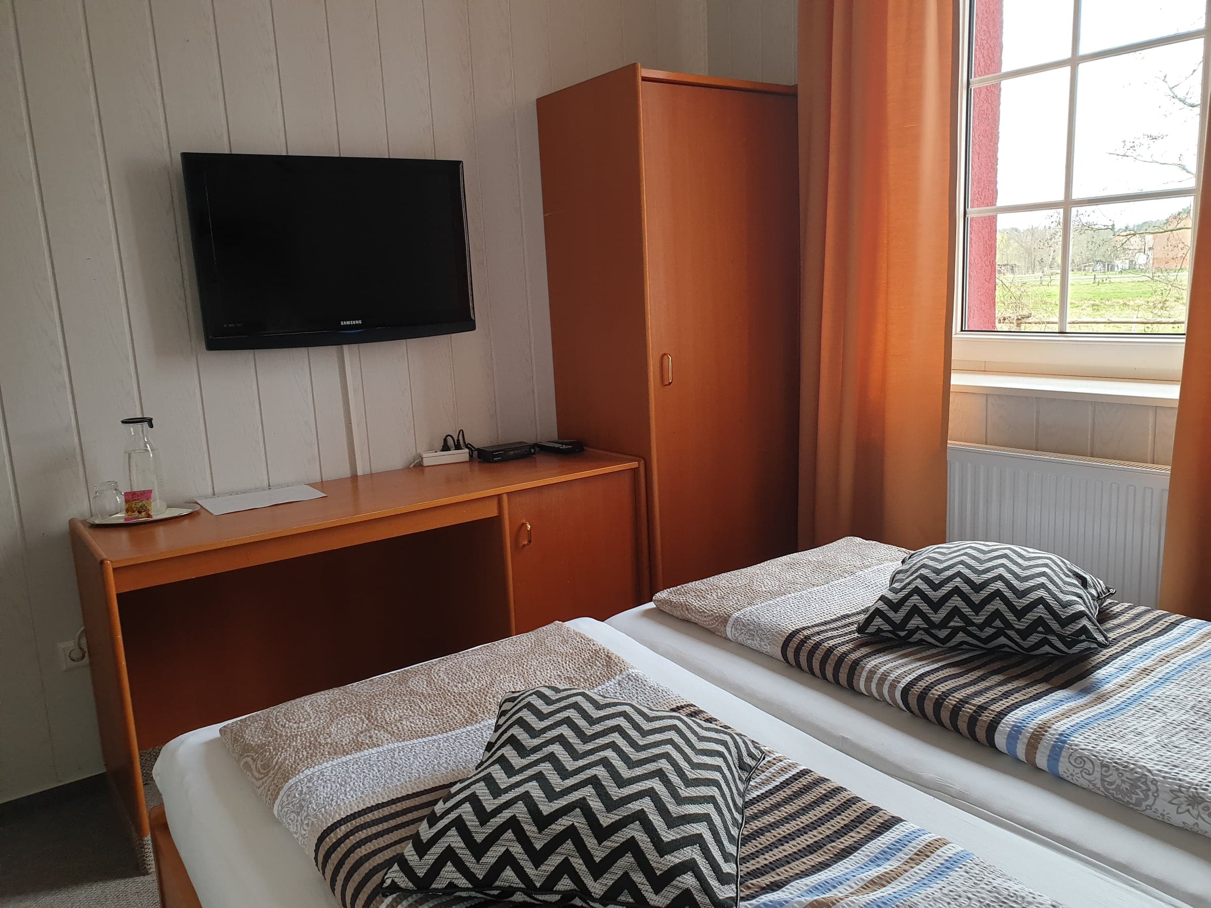 Doppelzimmer 2 mit Fernseher, Schreibtisch und Kleiderschrank